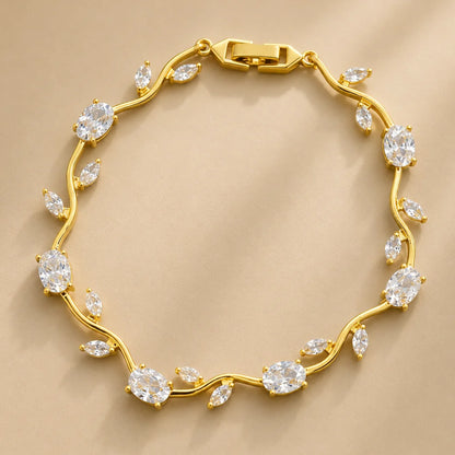 Gold bracelet with diamond-like stones on a beige background