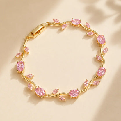 Gold bracelet with pink gemstones on a beige background